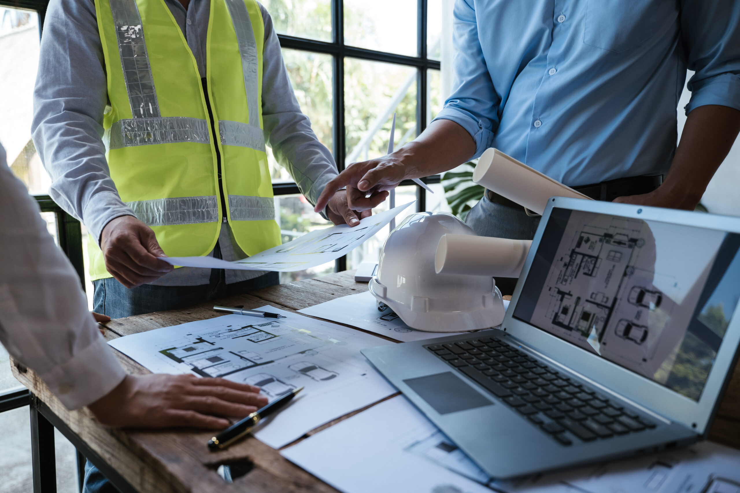 Close up of hands working and brainstorming on paperworks and floor plan drawings about design architectural and engineering for houses and buildings. Close up of hands working and brainstorming on paperworks and floor plan drawings about design architectural and engineering for houses and buildings