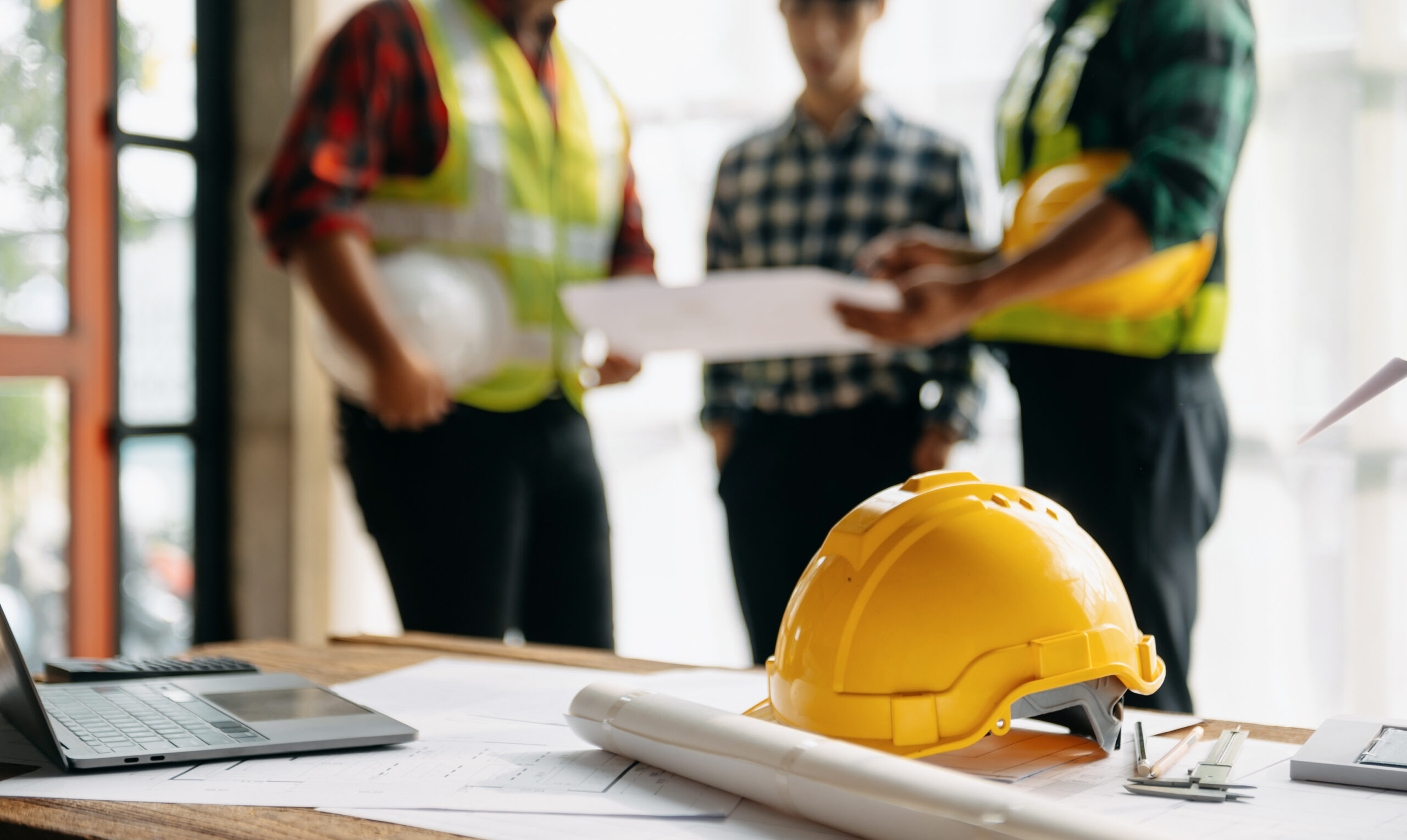 Engineer teams meeting working together wear worker helmets hardhat on construction site in modern city Asian industry professional team 